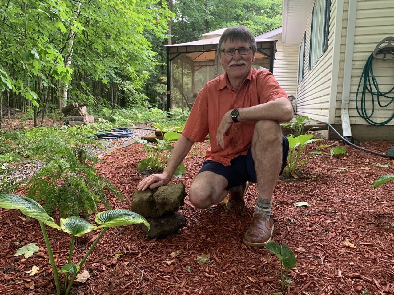 man kneeling in garden